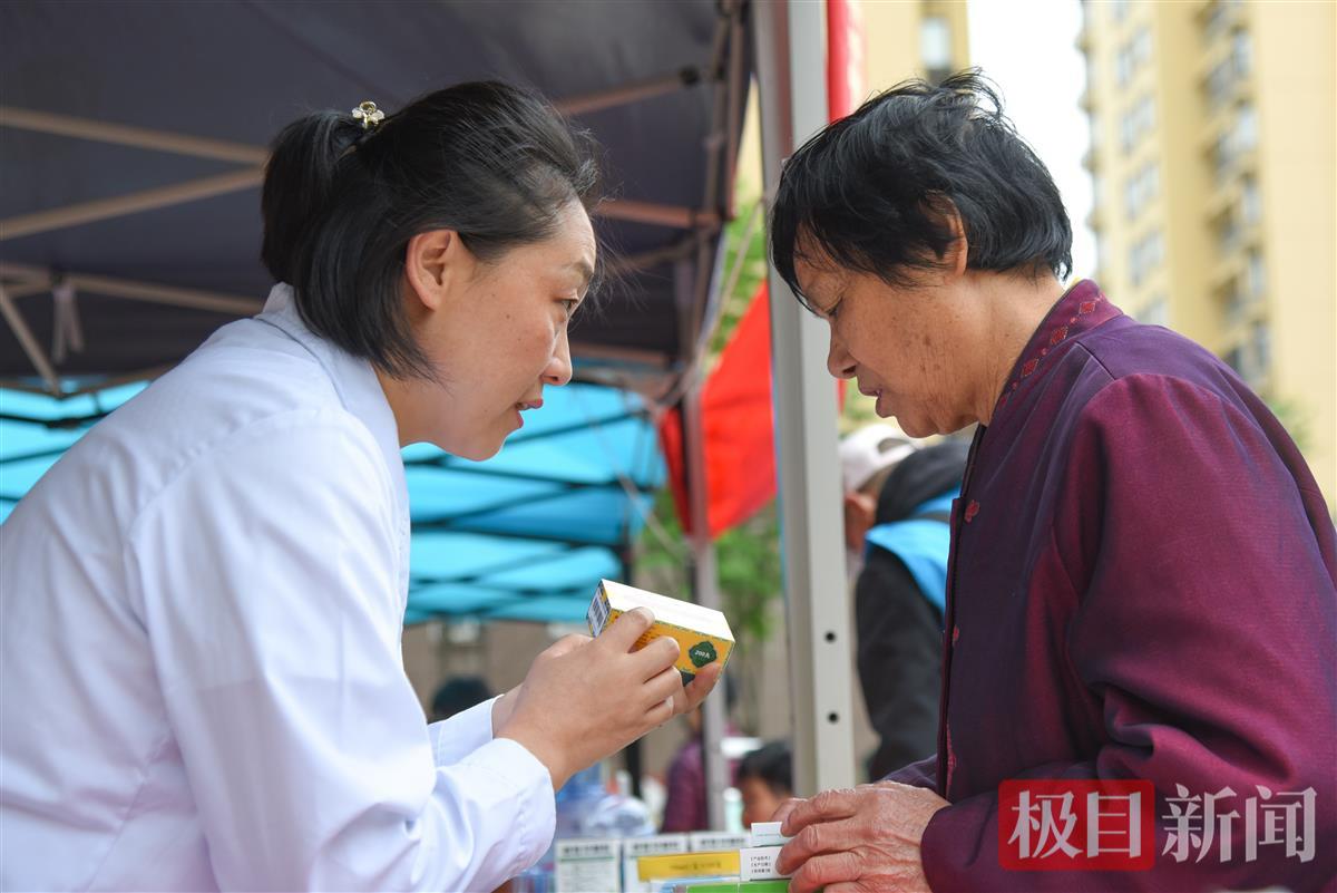 5月6日，彭贤钊在荆州经开区滩桥镇新桥社区开展义诊，妻子彭波向社区居民赠药。（极目新闻记者 黄志刚 摄）.jpg