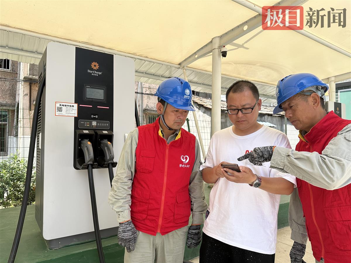国网石首市供电公司的“鄂电红马甲”正在对小区使用充电桩的用户进行使用操作提示（通讯员供图）.jpg