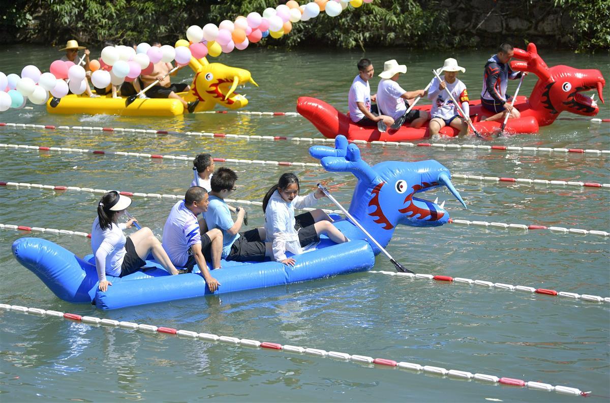 7月23日，人们在湖北省恩施土家族苗族自治州宣恩县高罗镇板寮村的溪水中参加趣味龙舟赛。.jpg