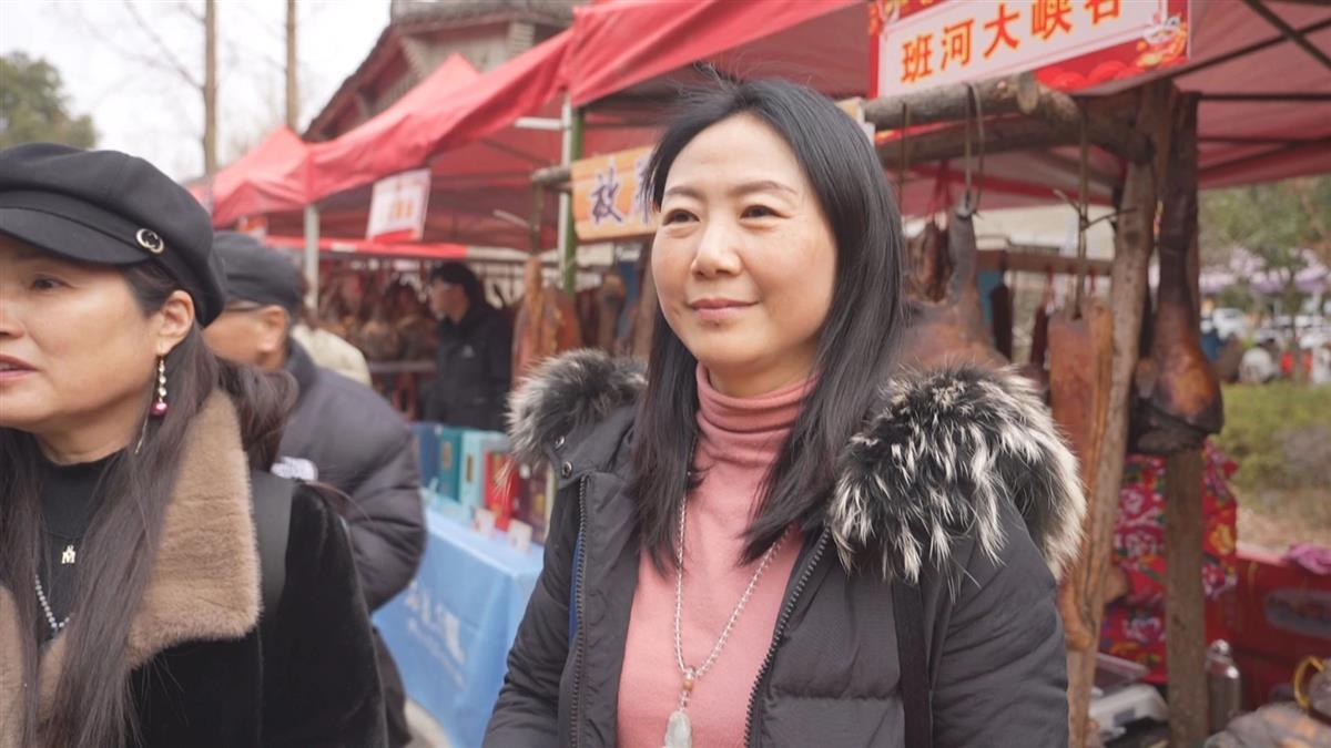 游客刘女士选购心仪的农特产品（通讯员 供图）.jpg