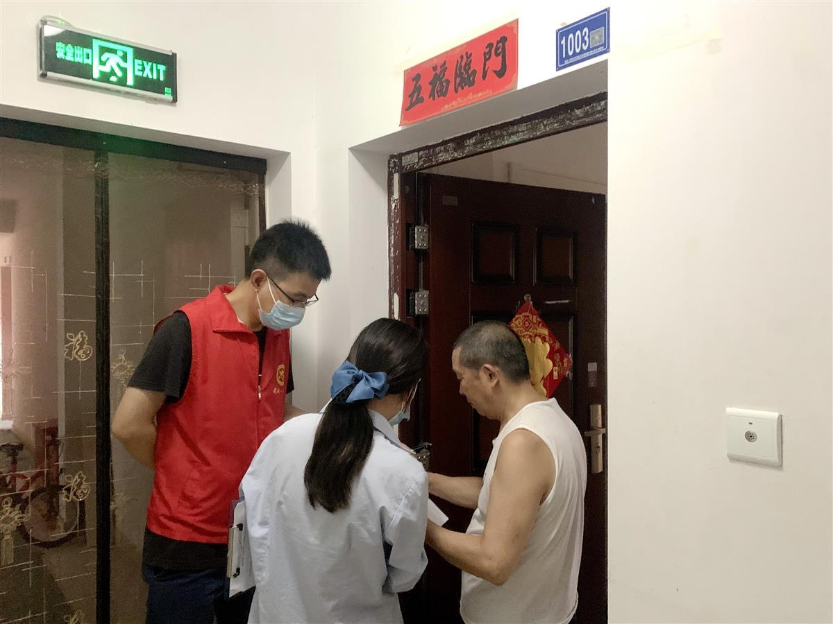 社区志愿者上门征询居民对增建电动车棚的意见