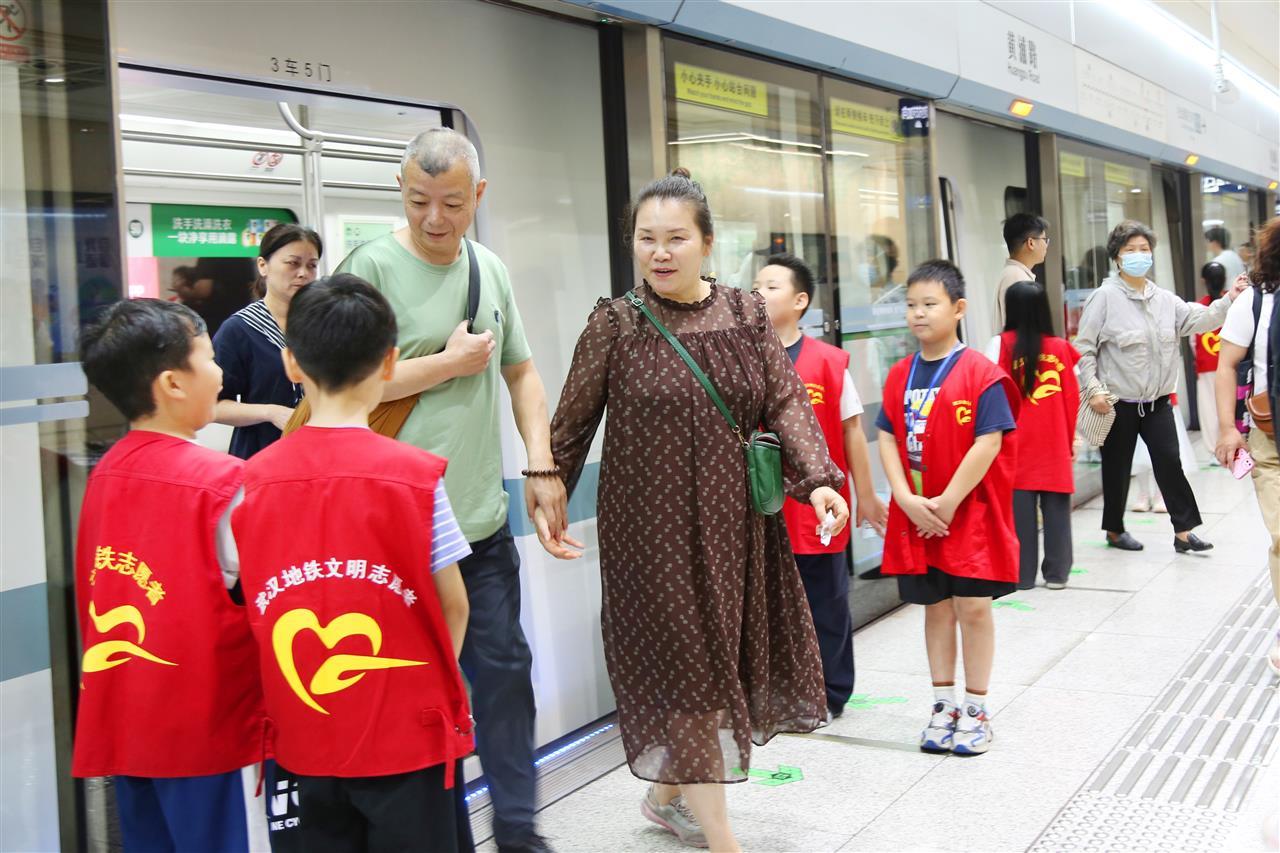 参与志愿者体验活动学生们在站台门前引导乘客安全上下车 王前摄.JPG