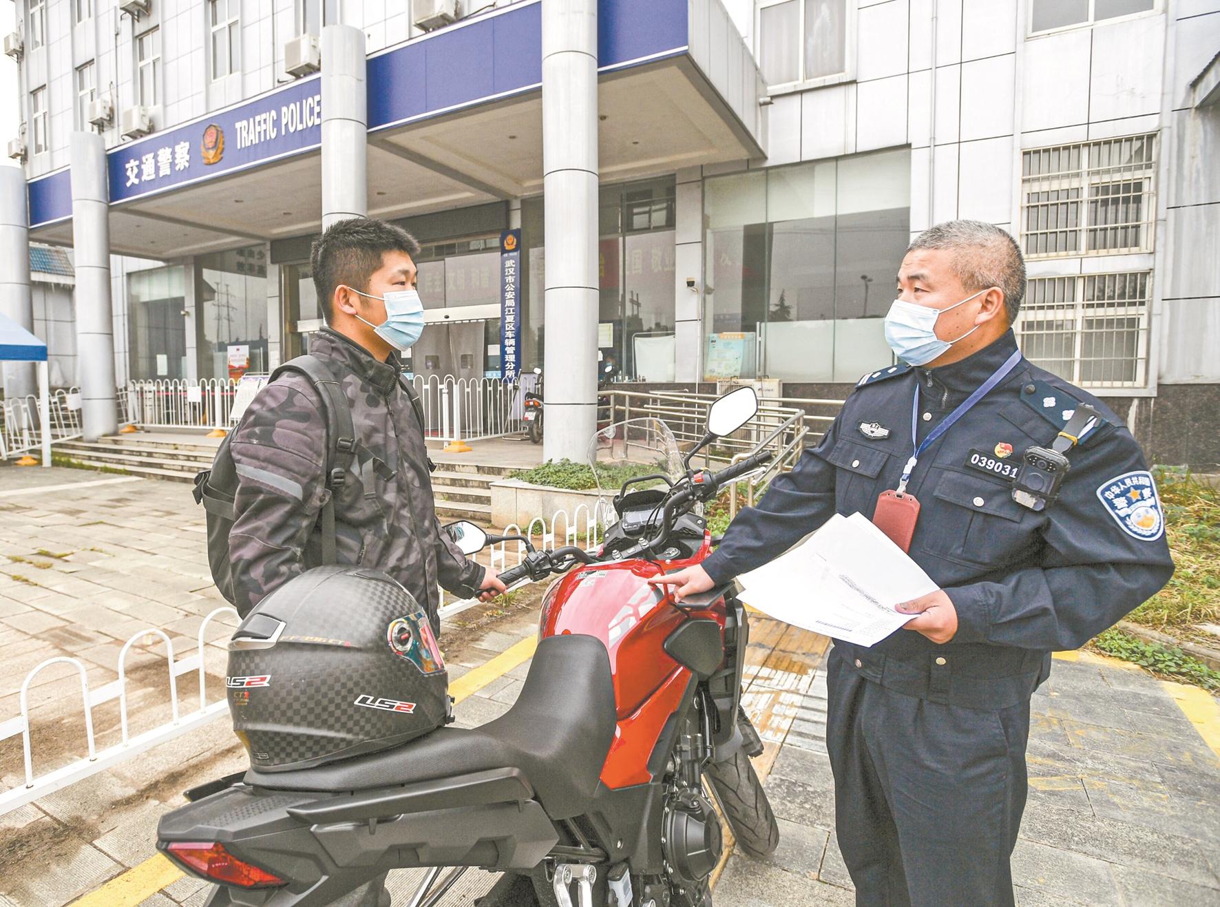 “武汉市五一劳动奖章”、江夏交通大队民警王勇旺正在对摩托车发证前审核