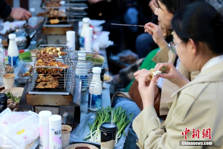山东淄博，食客正在享用烧烤。中新社记者 梁犇 摄