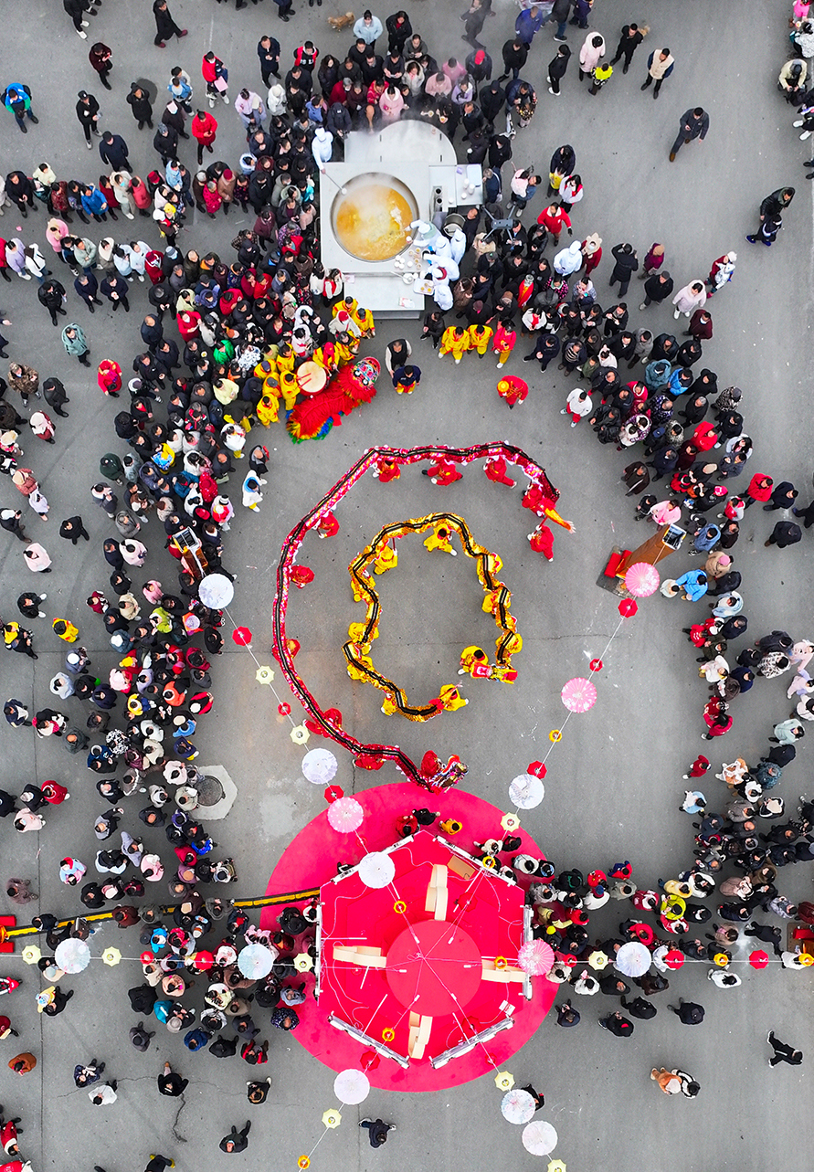 市民一遍品尝鲜美的汪集鸡汤，一遍欣赏精彩的舞龙表演。叶东辉 摄.jpg