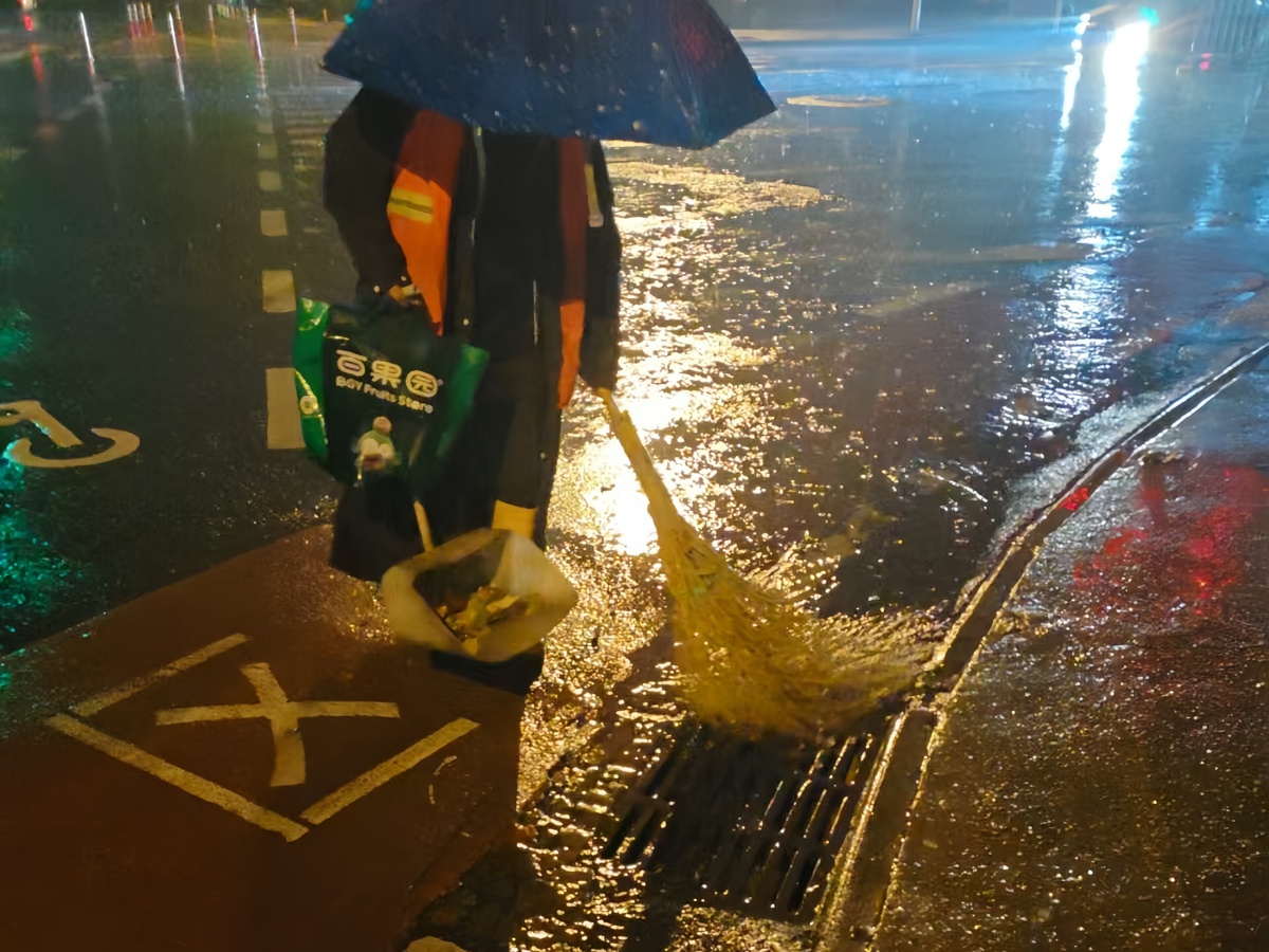 环卫工作人员凌晨到岗，冒雨清理窨井口杂物及积水 (3).jpg