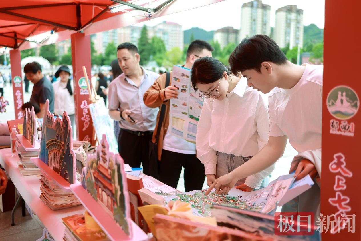 图为星火市集展区吸引众多游客驻足观赏购买。 郧宣文摄.png