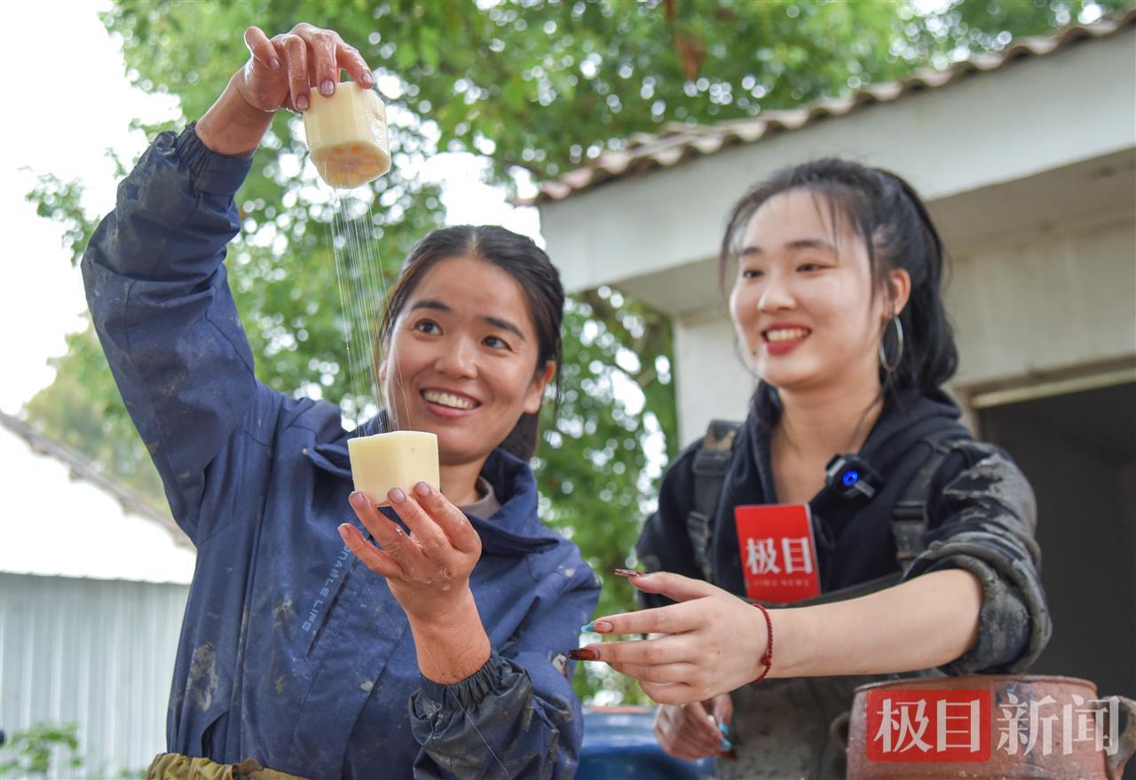 王文娟（左）向极目新闻记者展示洪湖莲藕切口拉出的长长藕丝（极目新闻记者 黄志刚 摄）.jpg
