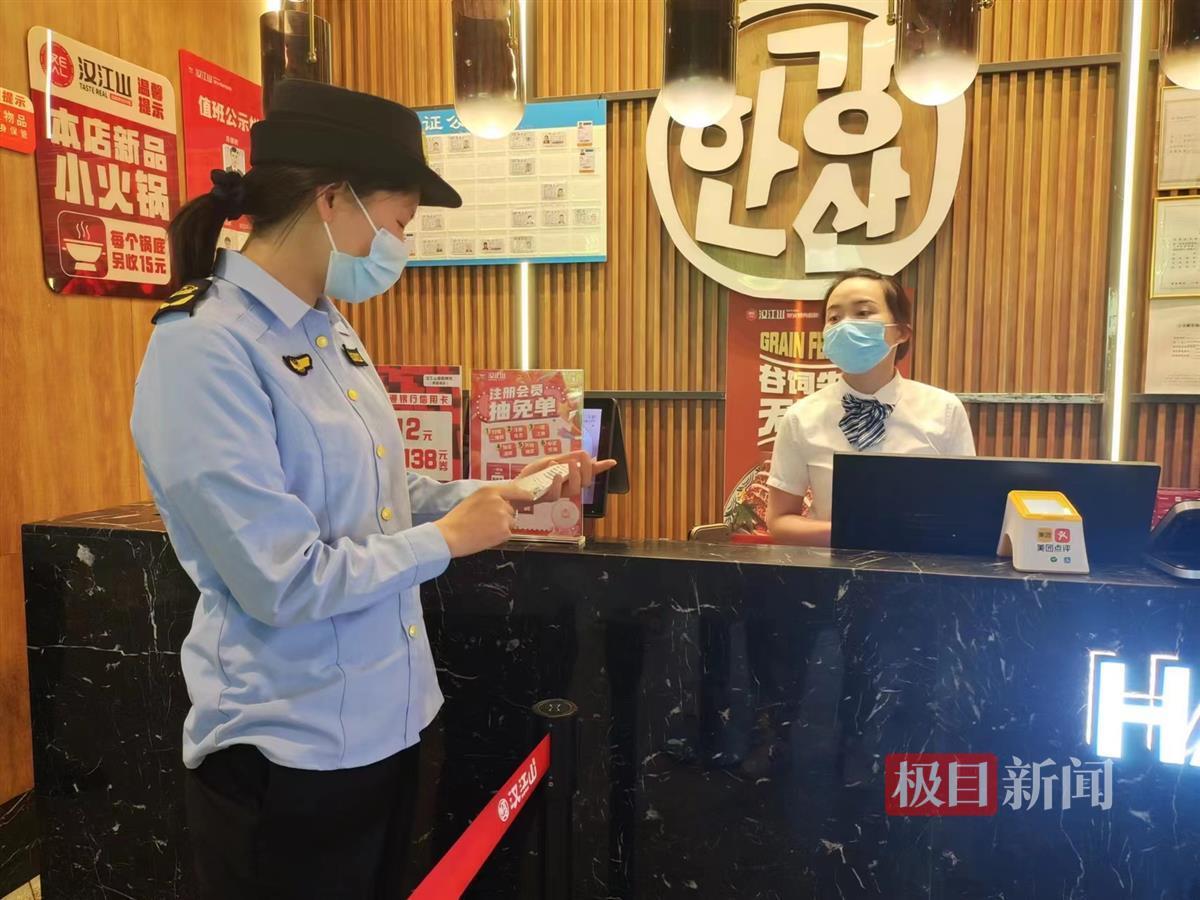 市场监管人员查看汉江山自助餐厅的押金单