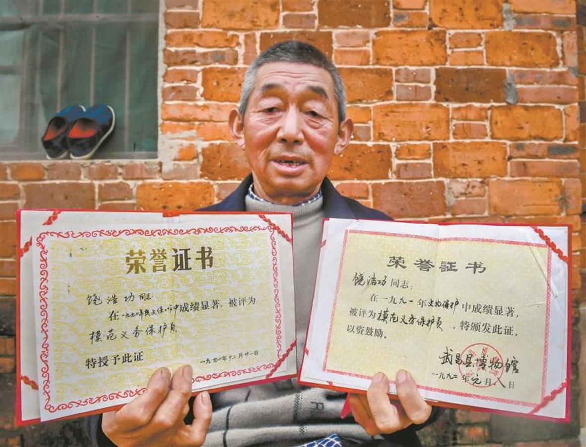 饶浩功展示模范义务保护员证书  Rao Haogong displays his certificates of Model Voluntary Conservator