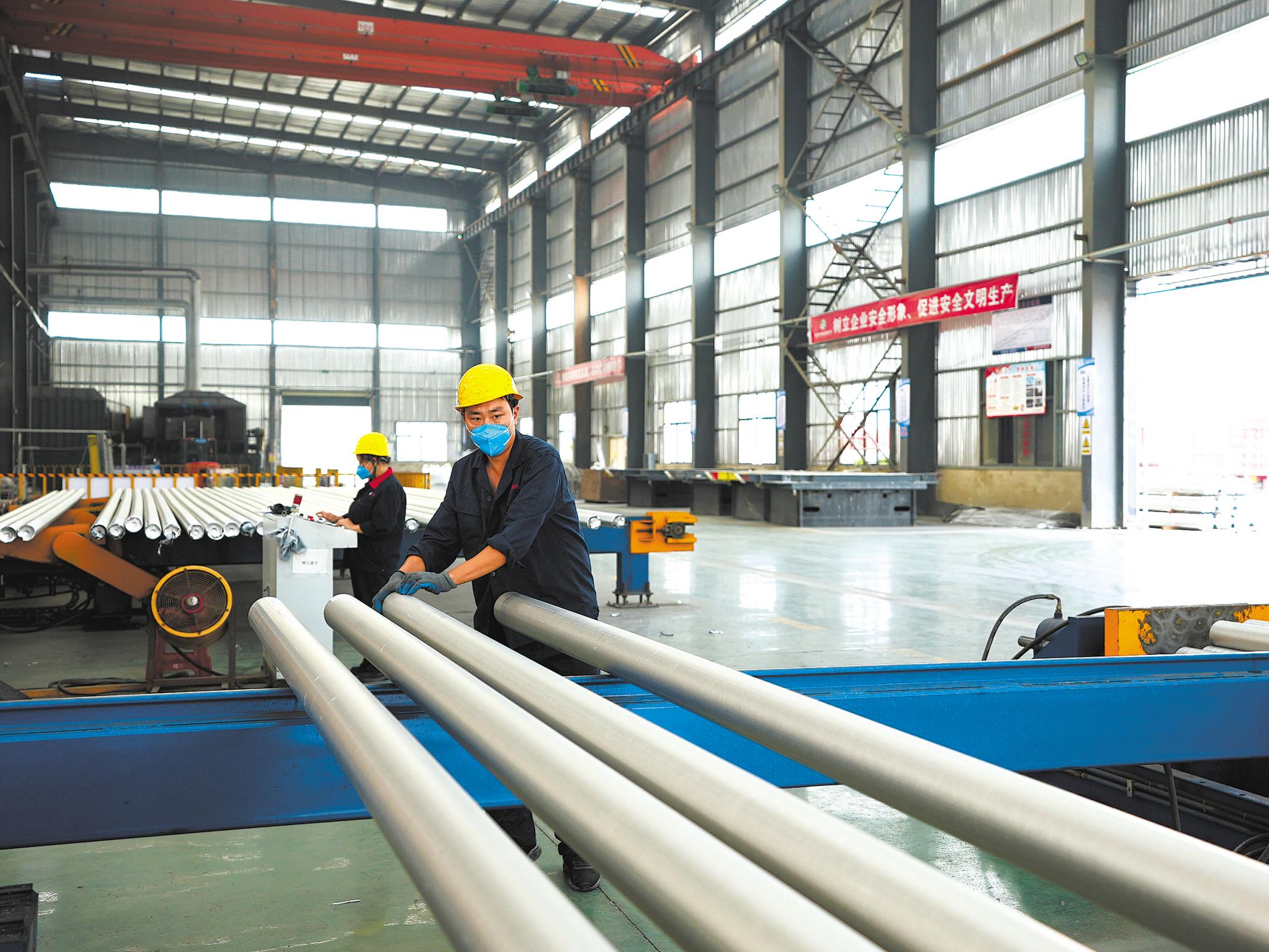 9月13日，鑫资铝业车间，工人在捆扎再生铝棒。 （通讯员 陈锐 摄）