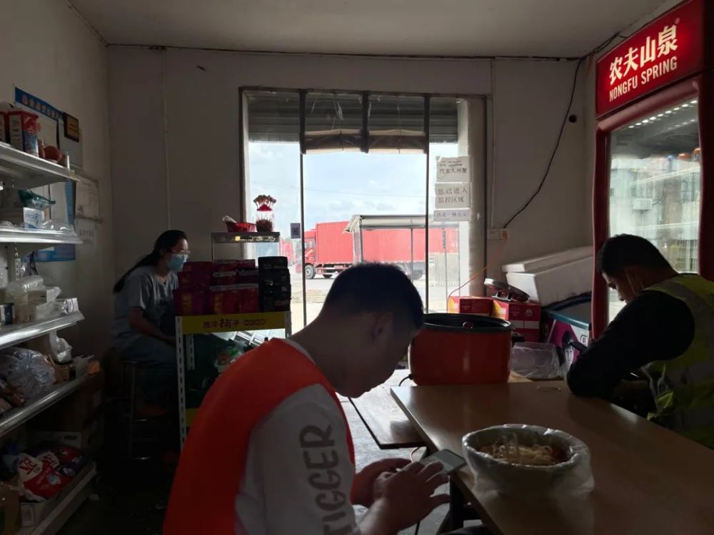 9月25日，阳澄湖镇澄消路上的一家快递中转站。工人们在对面的超市吃午饭，屋外是一排排引擎轰鸣的货车。新京报记者 杜寒三 摄