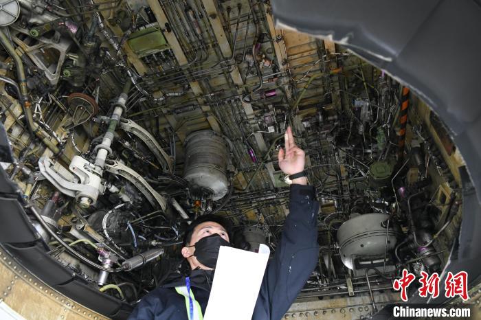 机务人员在检查飞机主轮舱 蒋雪林 摄