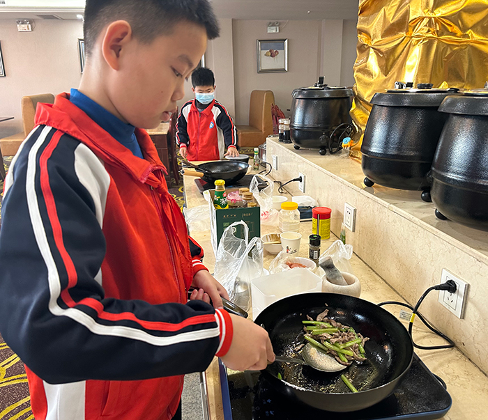 李京哲在烹饪菜肴（人民网 宋子节摄