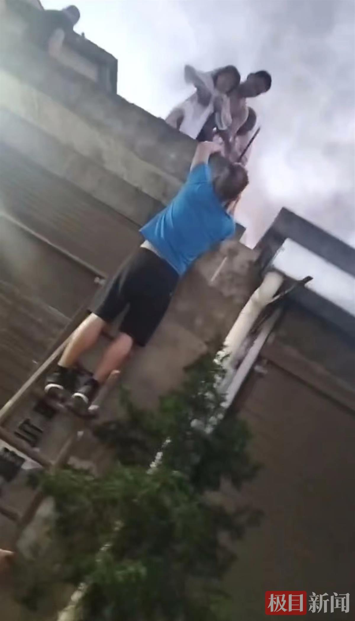 2023年7月5日，戴水文爬上梯子，借助肩膀转移被困火场的群众（视频截图）.jpg