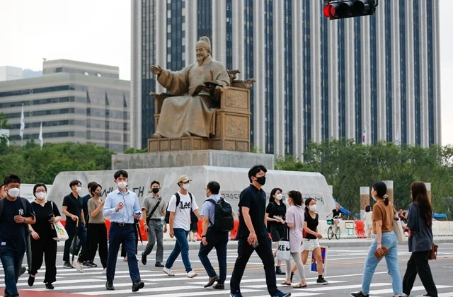 8月3日，行人佩戴口罩在韩国首尔光化门广场过马路。新华社