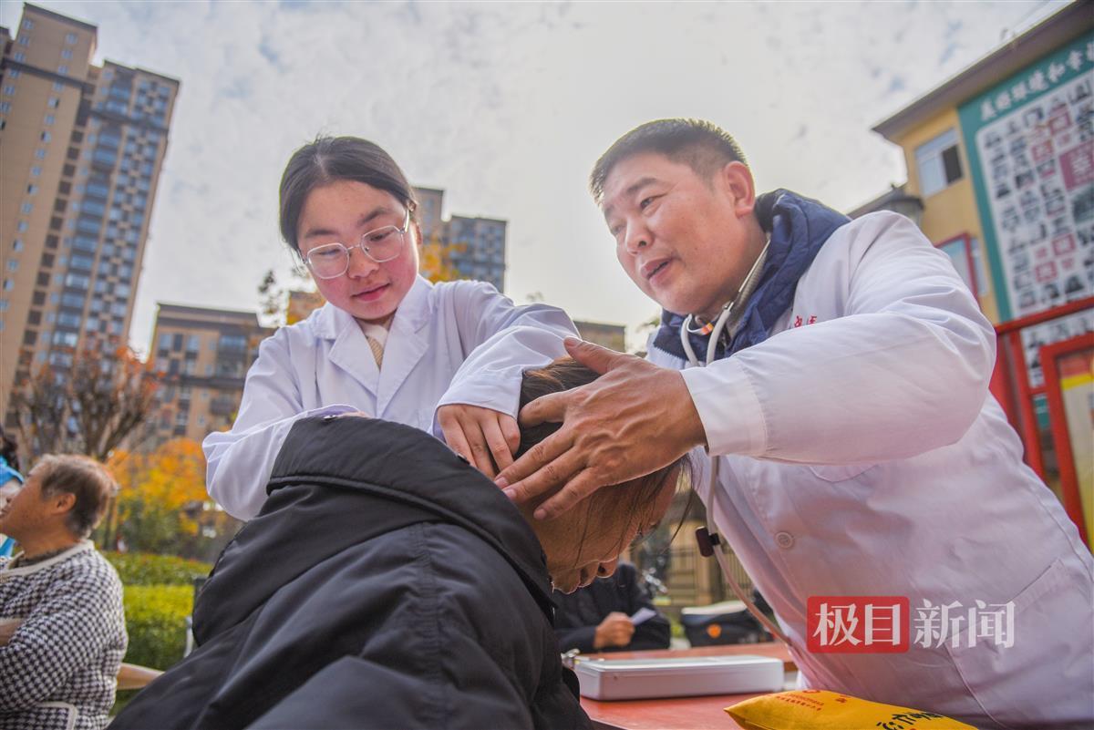 12月6日，彭贤钊（右）引导黄瑞为滩桥新城小区居民检查肩颈。（极目新闻记者 黄志刚 摄）.jpg