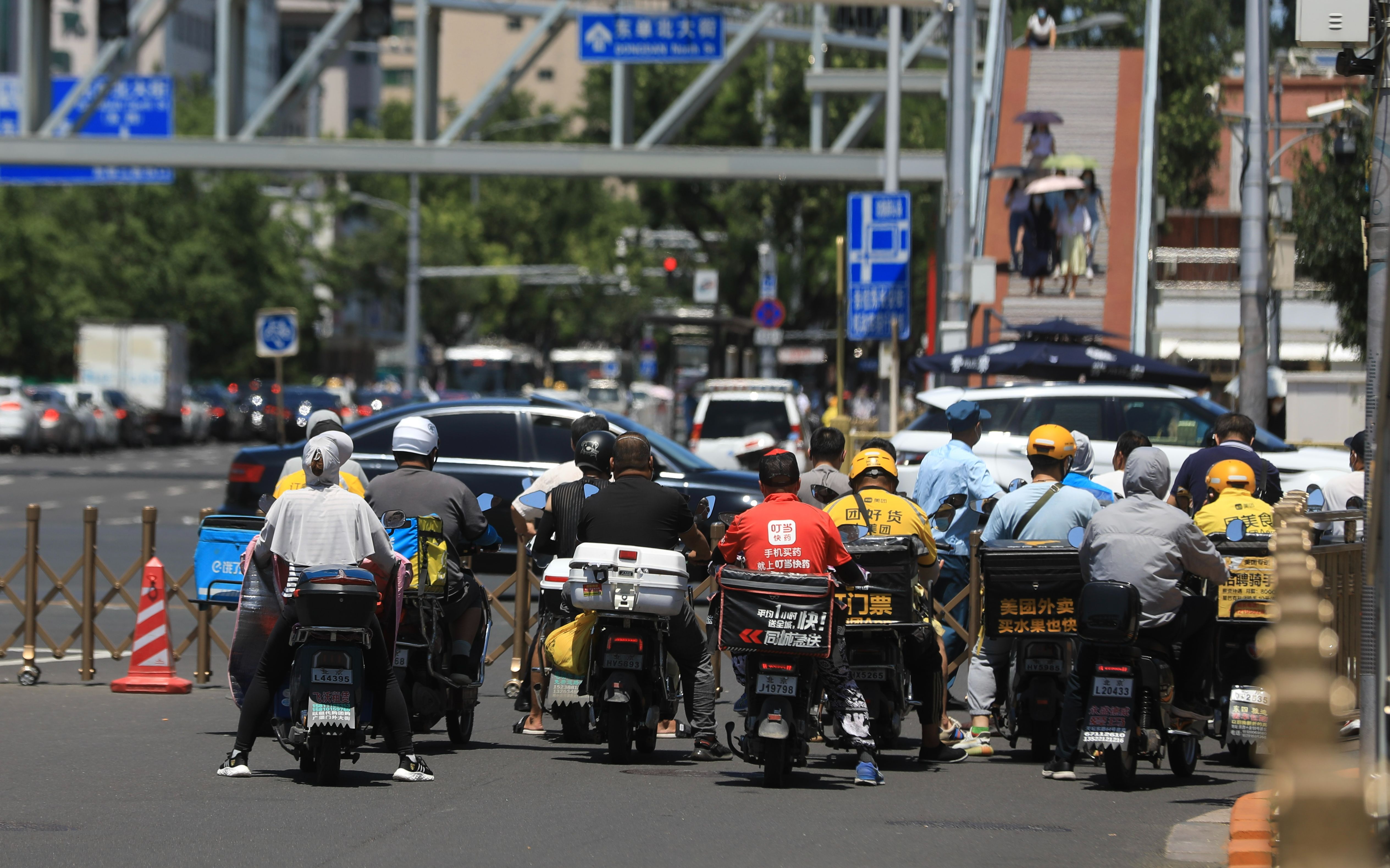 7月15日，北京东单路口，外卖员在烈日下等红绿灯。浦峰摄/ICphoto