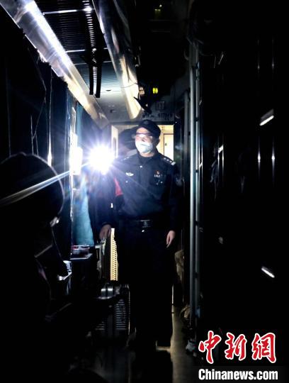 深夜乘警谢志平正在巡视车厢。　夏阳春 摄