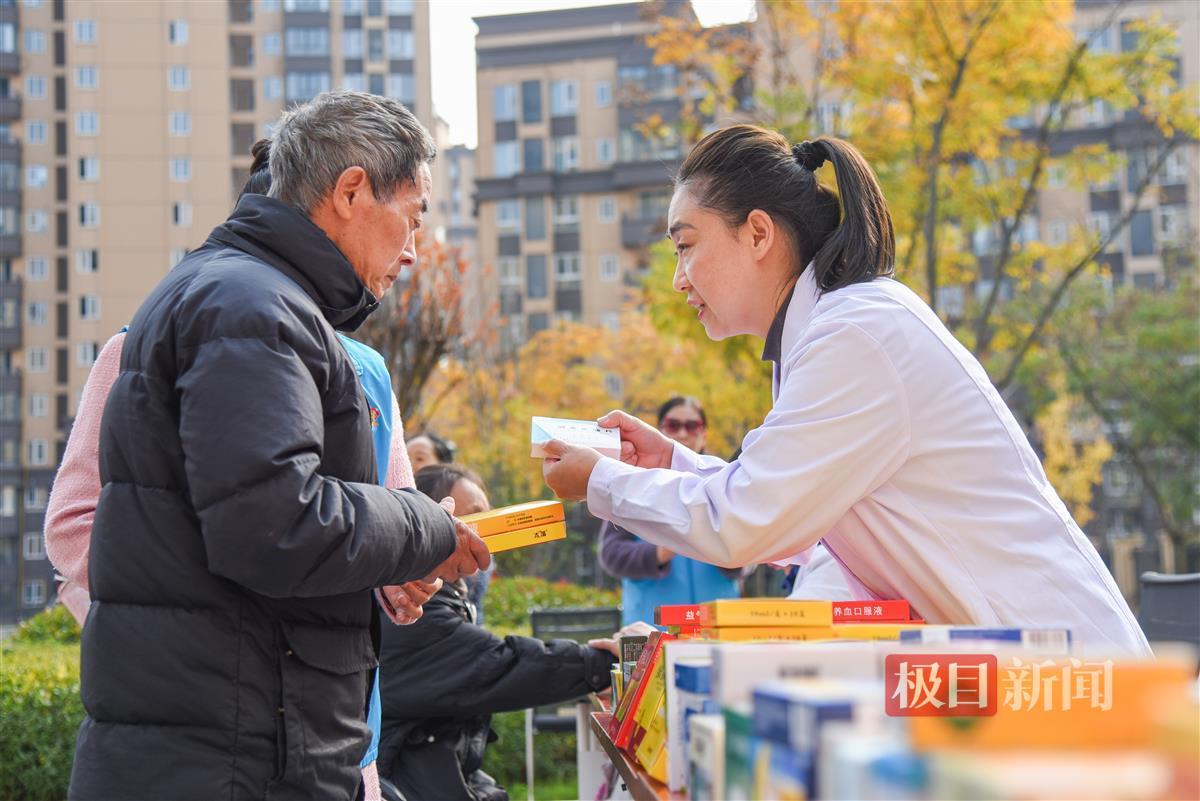 12月6日，彭贤钊的妻子彭波（右）在荆州经开区滩桥镇新桥社区，为滩桥新城小区居民赠药。（极目新闻记者 黄志刚 摄）.jpg