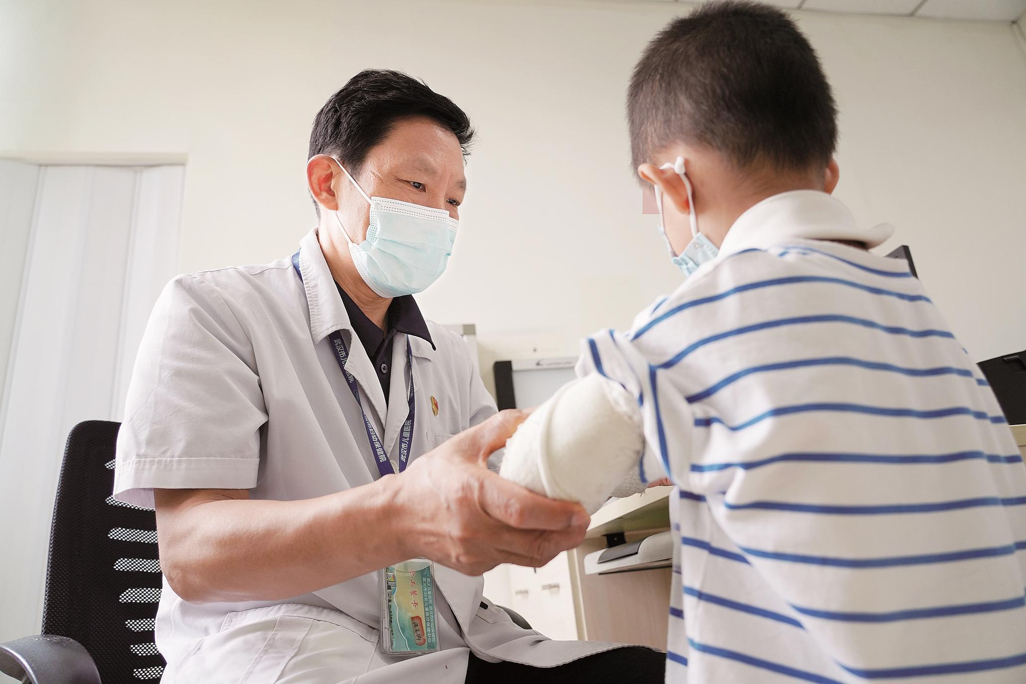 在武汉儿童医院骨科门诊，沈先涛主任为小朋友复查