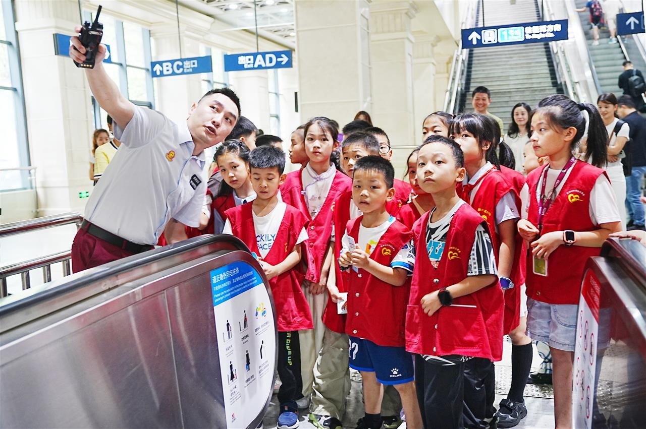 地铁工作人员向参与志愿者体验活动学生们介绍乘梯知识 林奎摄.JPG
