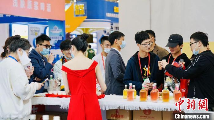 不少年轻人正在试饮蜂蜜果酒。　陈其浩 供图