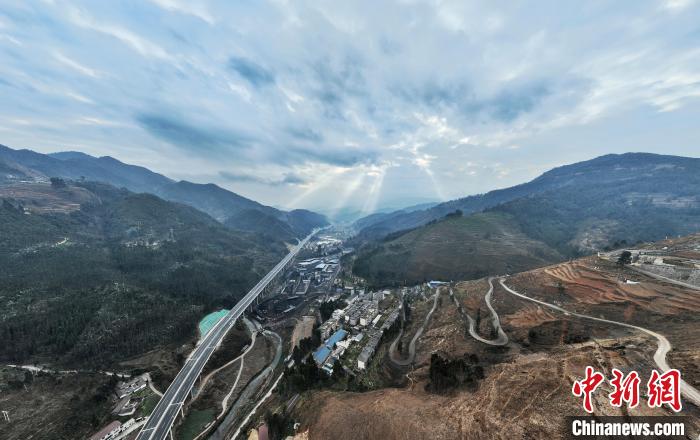 笔直的高速公路与旁边弯弯曲曲的山路相映衬。　王云 摄