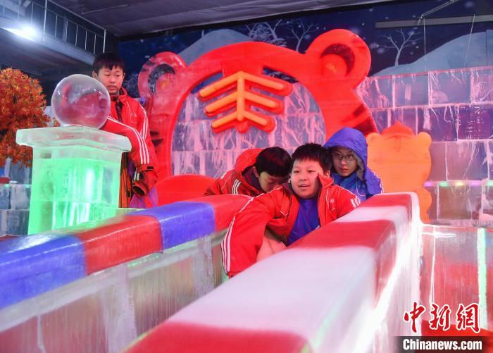 图为游客在邯郸市永年区广府镇东街村冰雕艺术馆游玩。　胡高雷 摄