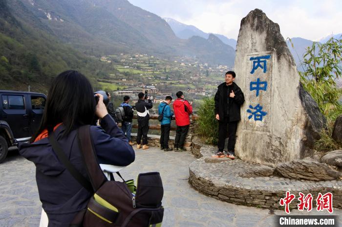 图为自驾游客在丙中洛观景台打卡拍照。　罗婕 摄