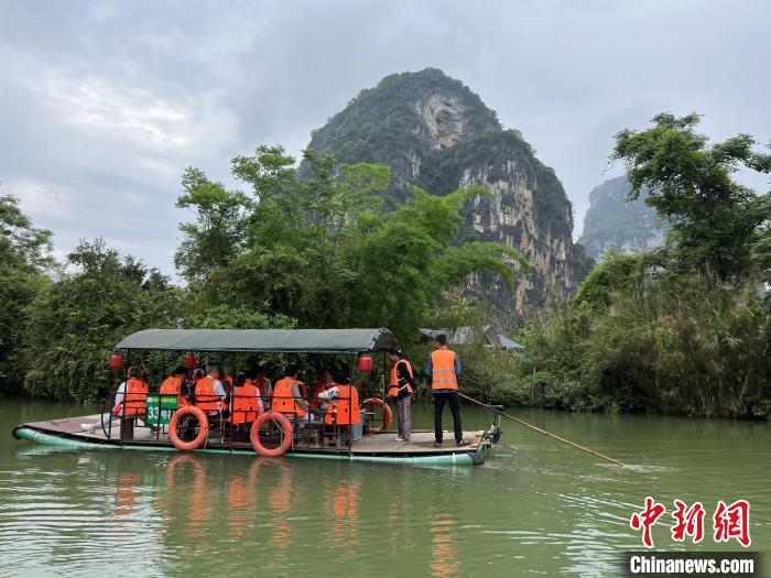 游客在明仕河乘坐竹筏游览两岸风光。　张文茜 摄