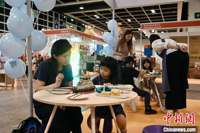 家长与孩子参与游戏。　李志华 摄