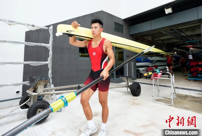 图为男子双人双桨选手肩扛赛艇准备下水训练。　侯宇 摄