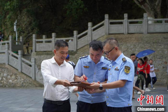 友谊关口岸国际道路运输管理处执法人员对入境提前预约客车进行《国际汽车运输行车许可证》现场查验、签章。　黄中 摄