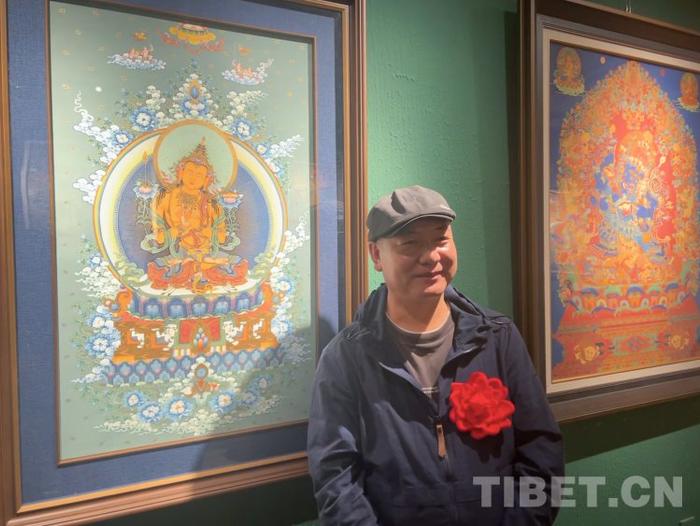 图为唐卡画师夏鲁旺堆与他的唐卡作品《文殊菩萨》（左）摄影：赵振宇