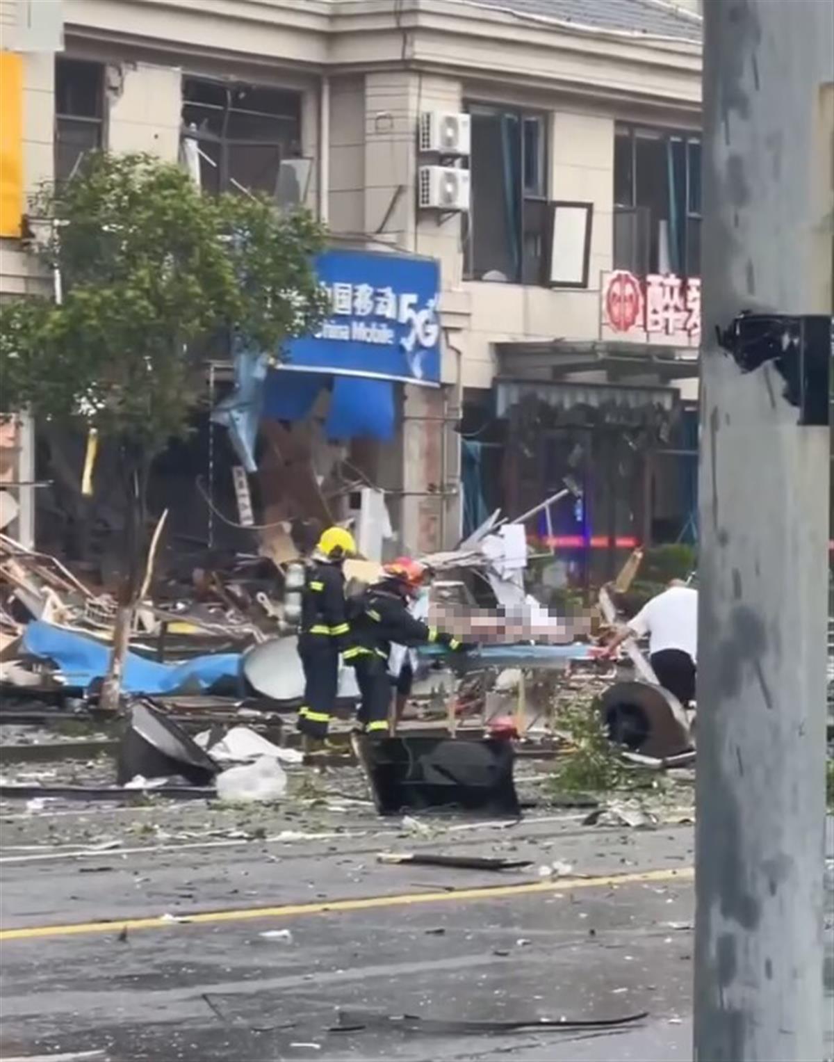 一医护人员从爆炸现场抬走一名伤者（来自网络）