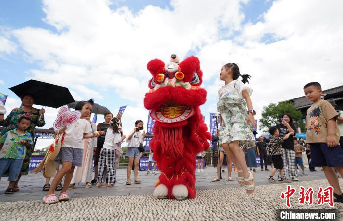 图为小朋友与“南海醒狮”表演者互动。　黄晓海 摄