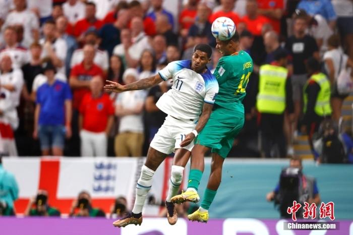 当地时间12月4日，2022卡塔尔世界杯1/8决赛继续进行，英格兰队对阵塞内加尔队的比赛正式打响。本场比赛，英格兰队凭借亨德森、凯恩和萨卡的进球，以3：0完胜对手，连续两届世界杯进入八强。图为英格兰队球员拉什福德(左)与塞内加尔队球员雅各布斯争抢头球。<a target='_blank' href='/'>中新社</a>记者 富田 摄 鍏抽棴