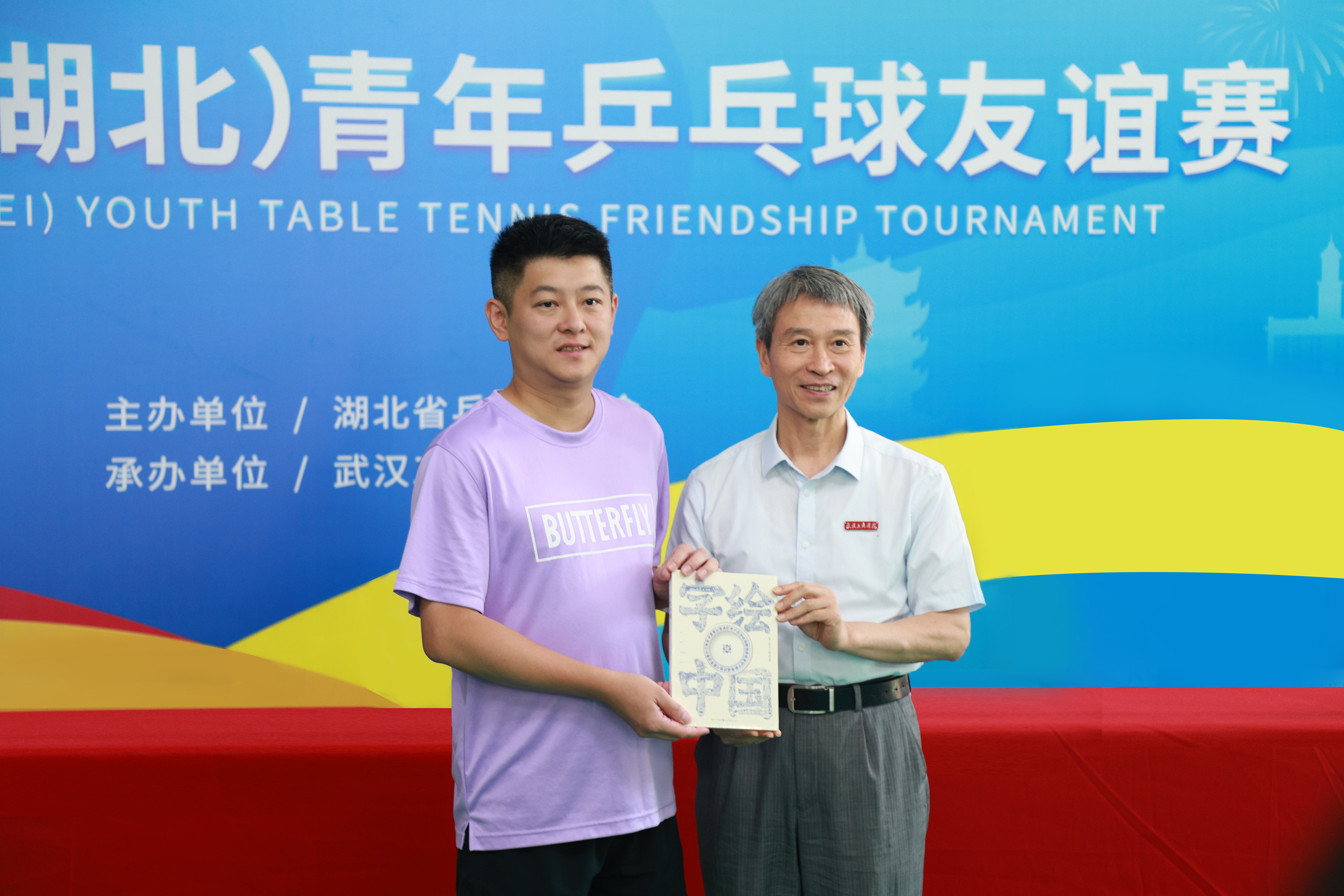 图为学校校长孔建益向台湾乒乓球代表团领队柯建利赠送《字绘中国》书籍 摄影：芮雨欣.jpg