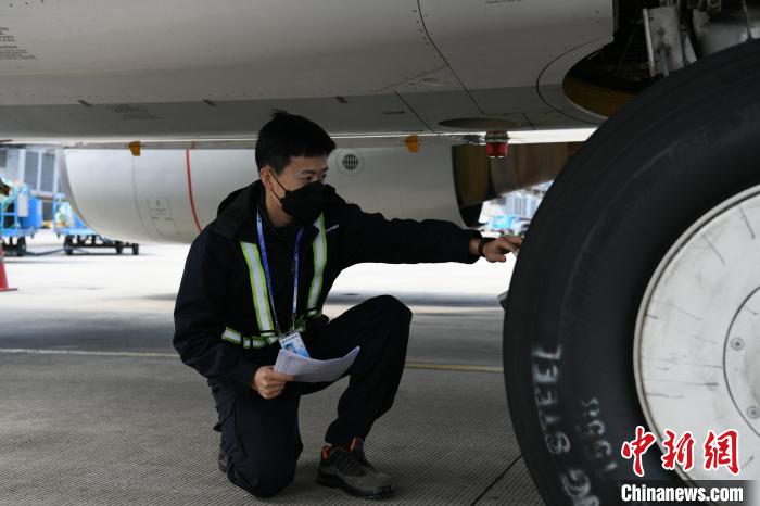 机务人员在检查飞机起落架。　蒋雪林 摄