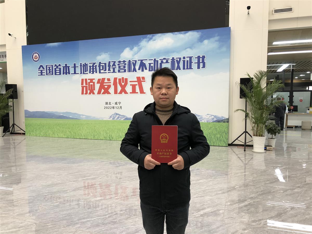 咸安区农民江维手捧全国第一本土地承包经营权不动产权证书