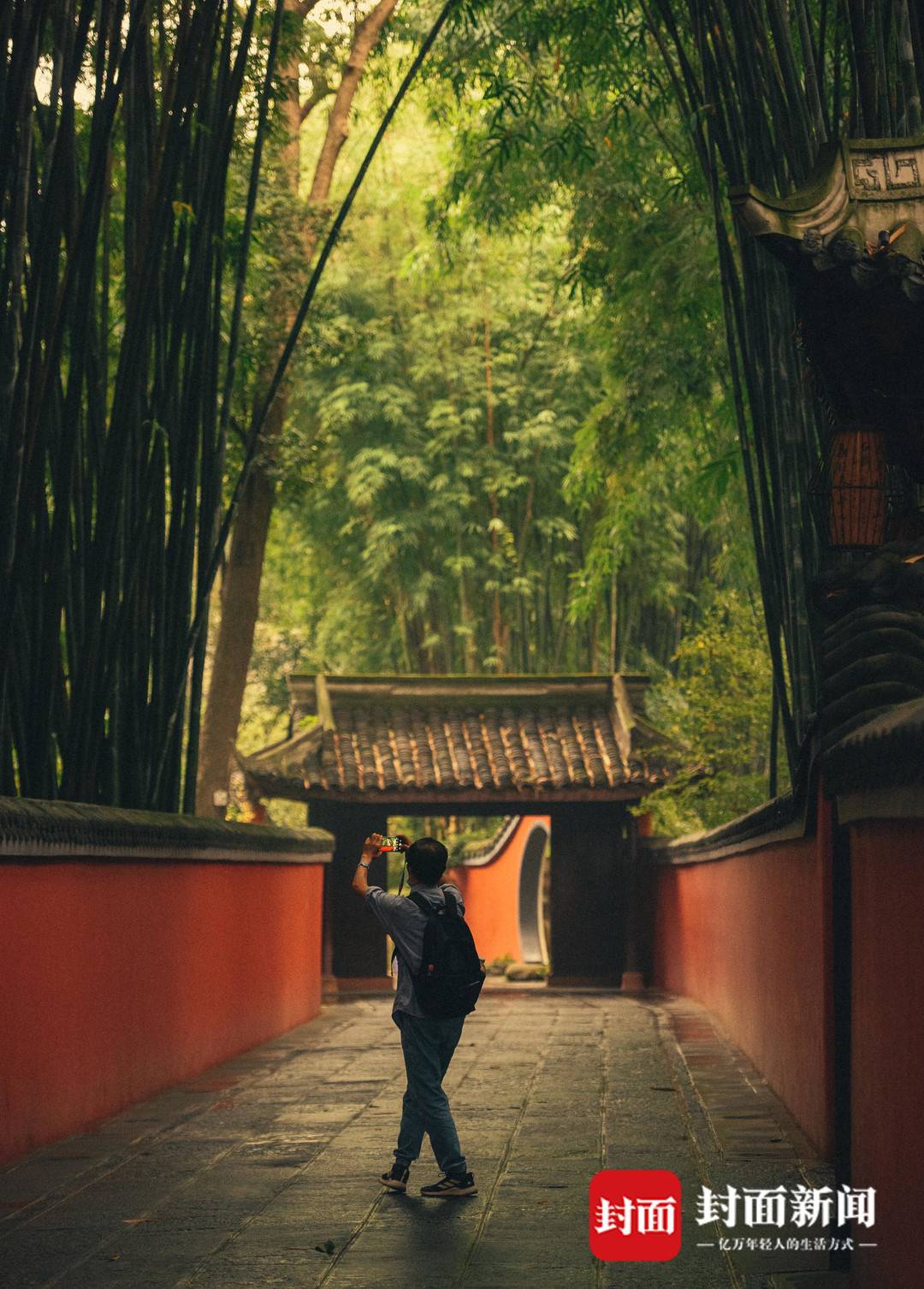 成都杜甫草堂内，红墙之下，游人在拍照留念。
