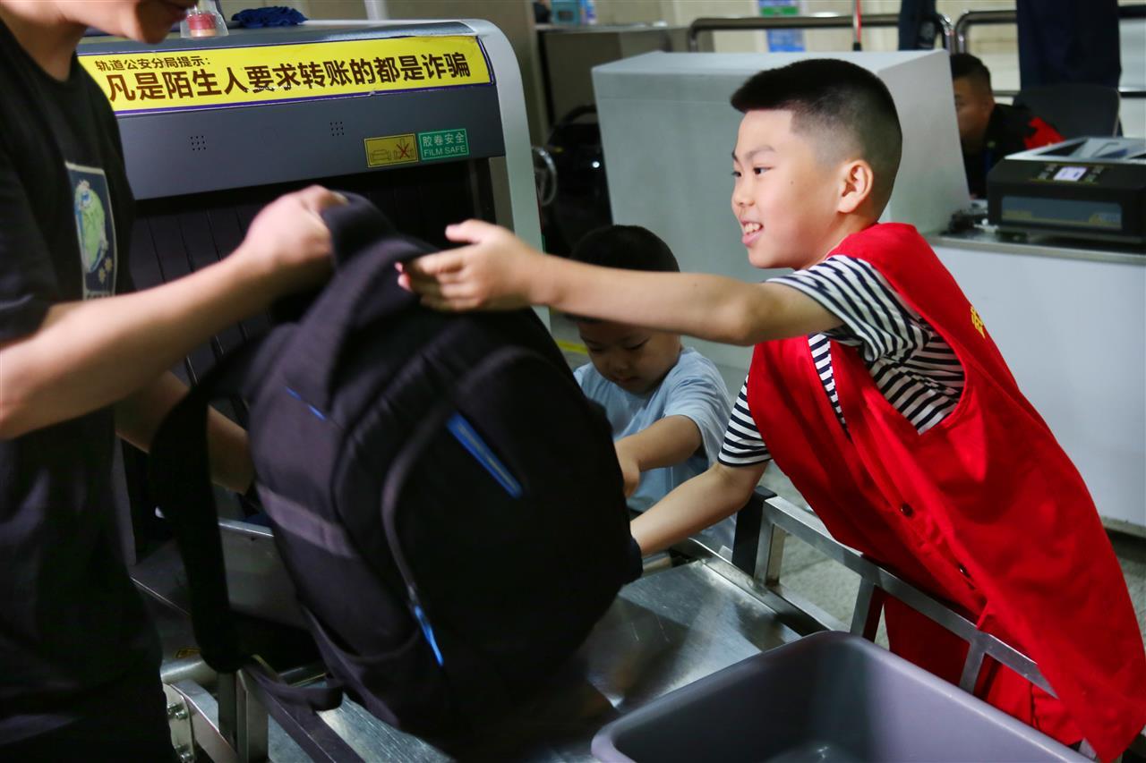 参与志愿者体验活动学生们帮助乘客过安检 王前摄.JPG