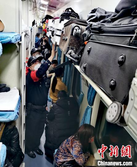 乘警谢志平带着廖武干正在检查车厢内的行李摆放。　夏阳春 摄