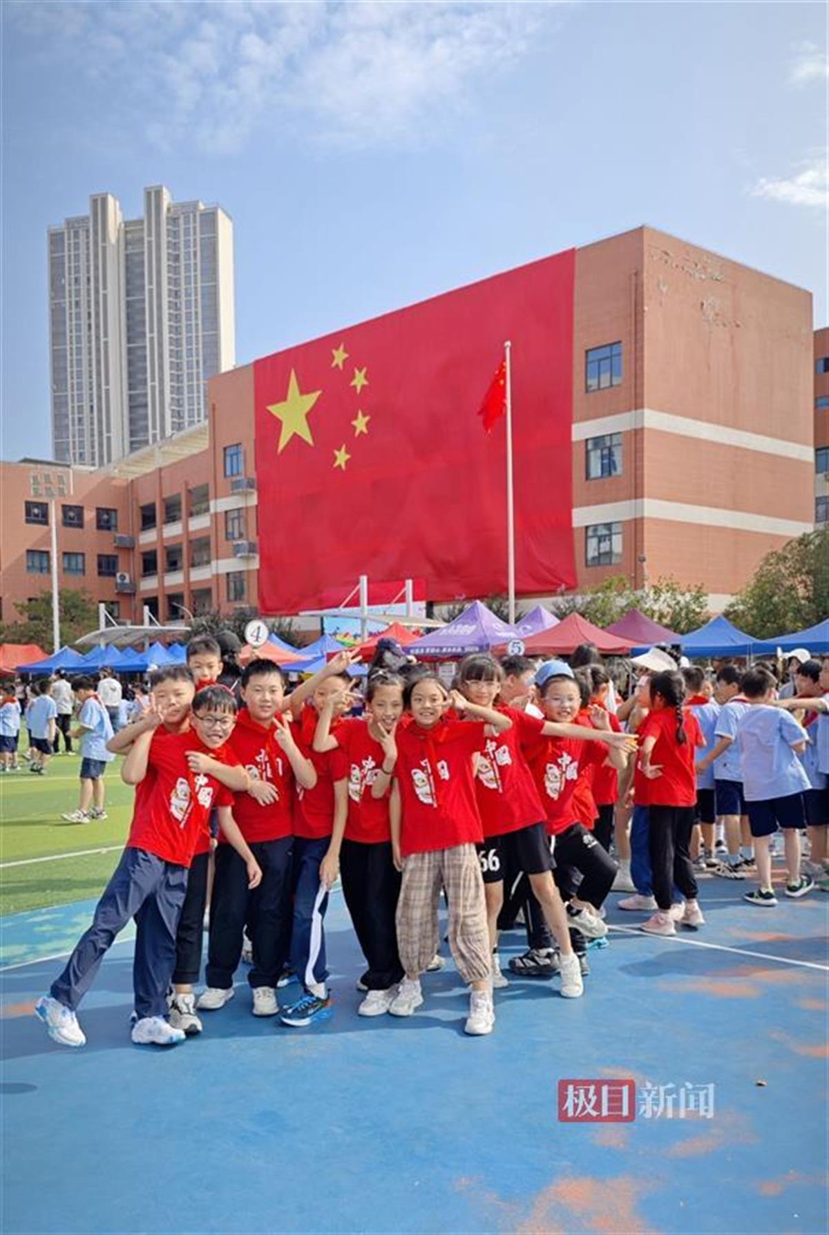 1洪山区第一小学书城路分校的同学们和巨幅国旗合影.jpg