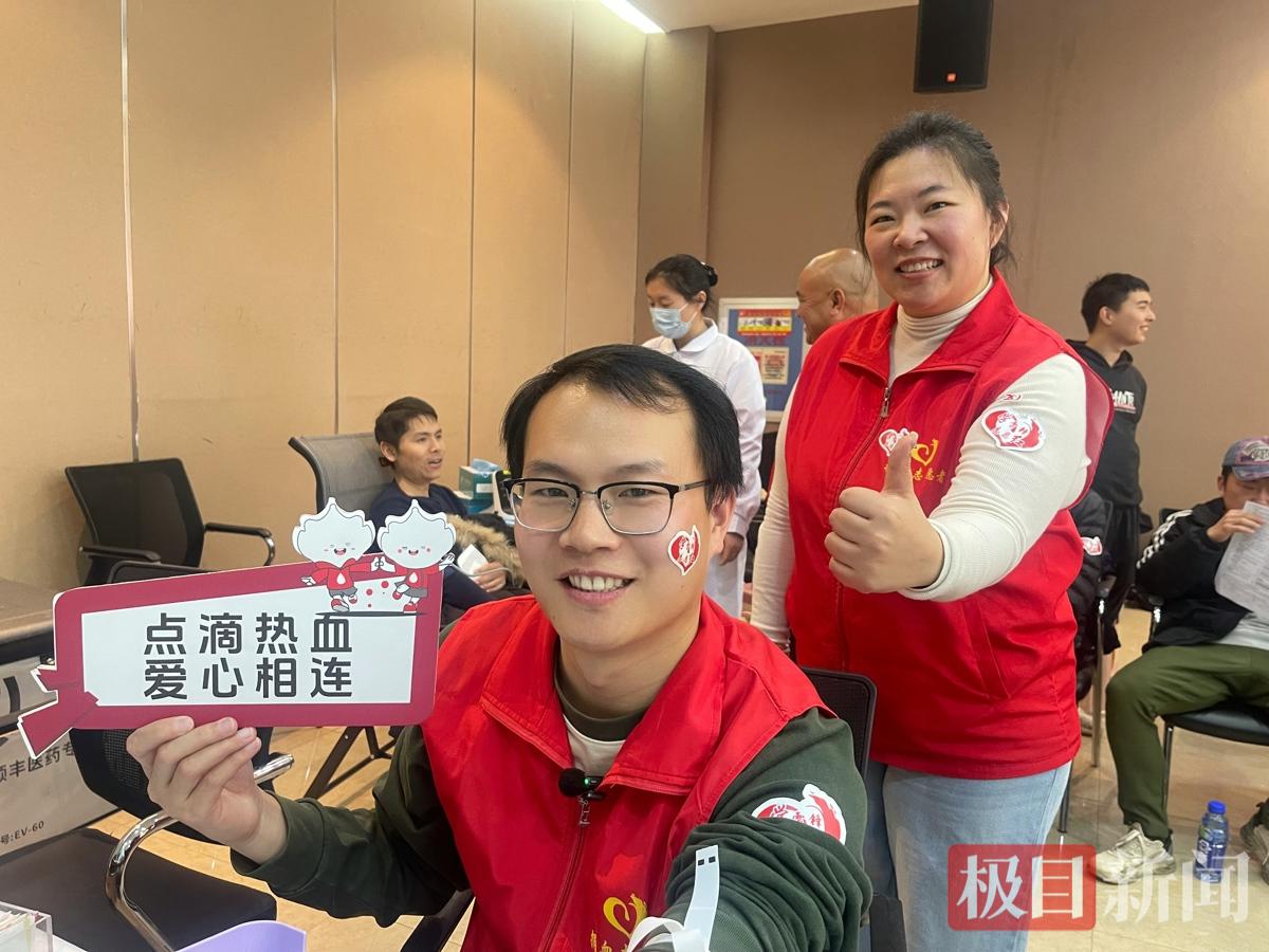 汪阳雄正在献血，志愿者“小伙伴”姚芳为其点赞（肖莉娇摄）.jpg
