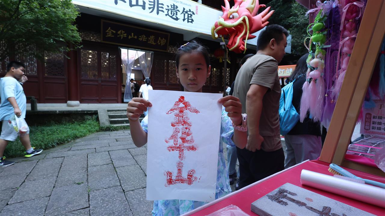 图为一名游客在景区手拿字绘“金华山”作品合影.jpeg