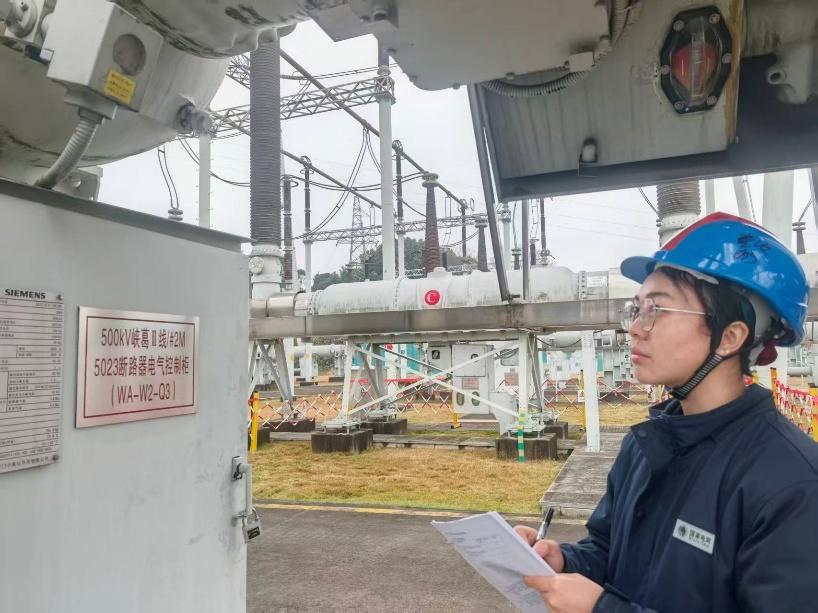 国网湖北直流公司一次检修二班工作负责人杜灿正在记录5023断路器SF6密度继电器数据。 李古月 摄.png