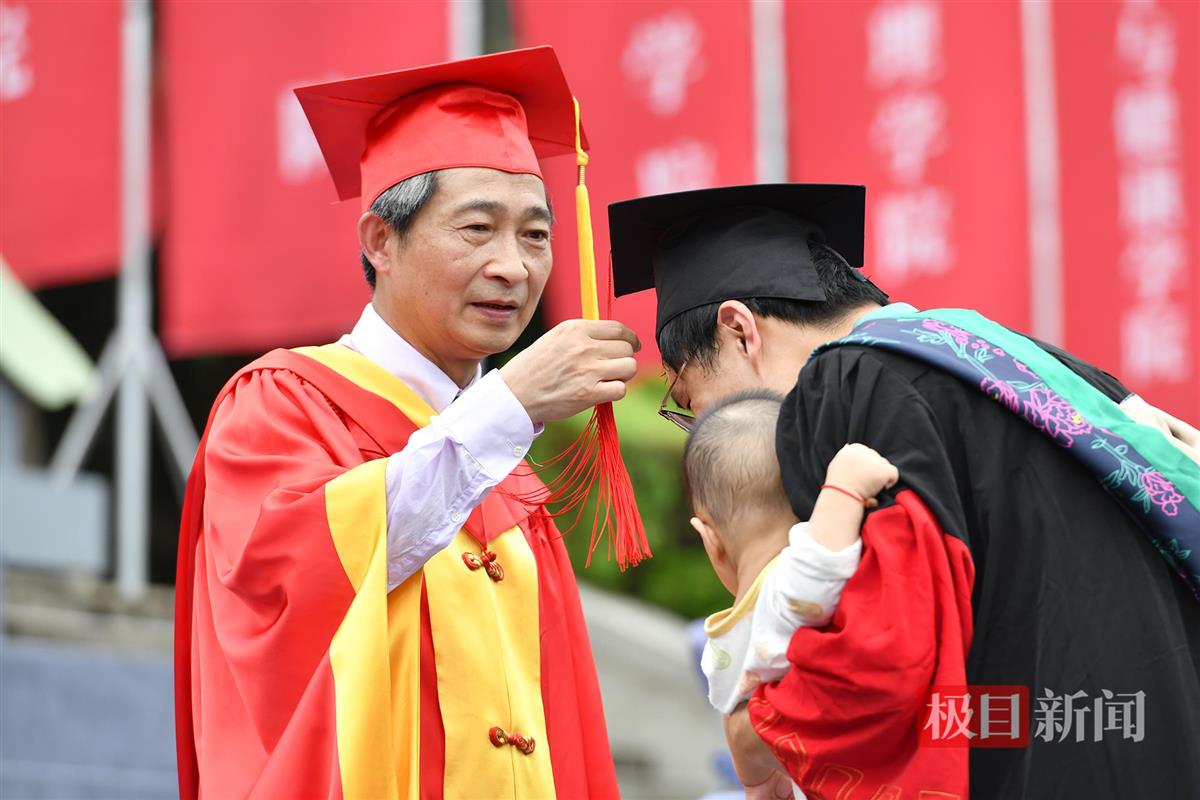 校党委书记高翅为毕业生正冠拨苏（记者 刘涛 摄）