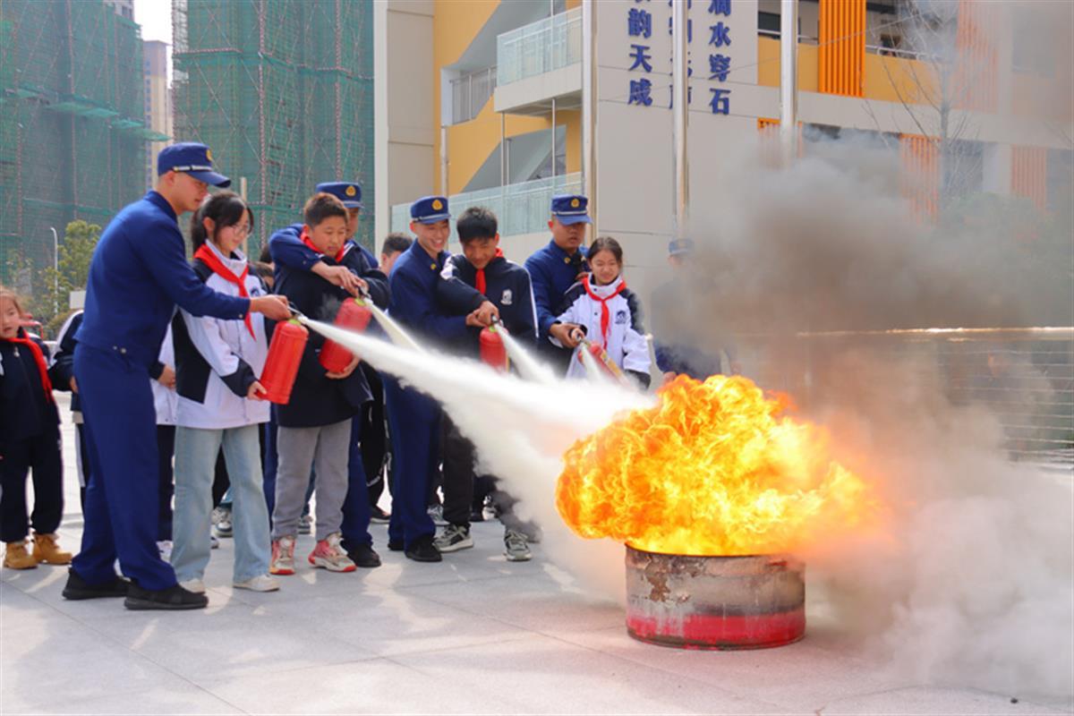 消防救援人员指导学生开展灭火实操.jpg